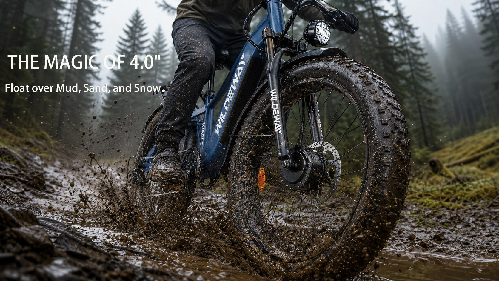 Close-up of the WILDEWAY SOARED 26x4.0 inch fat tire powering through deep mud and snow, showing massive traction.