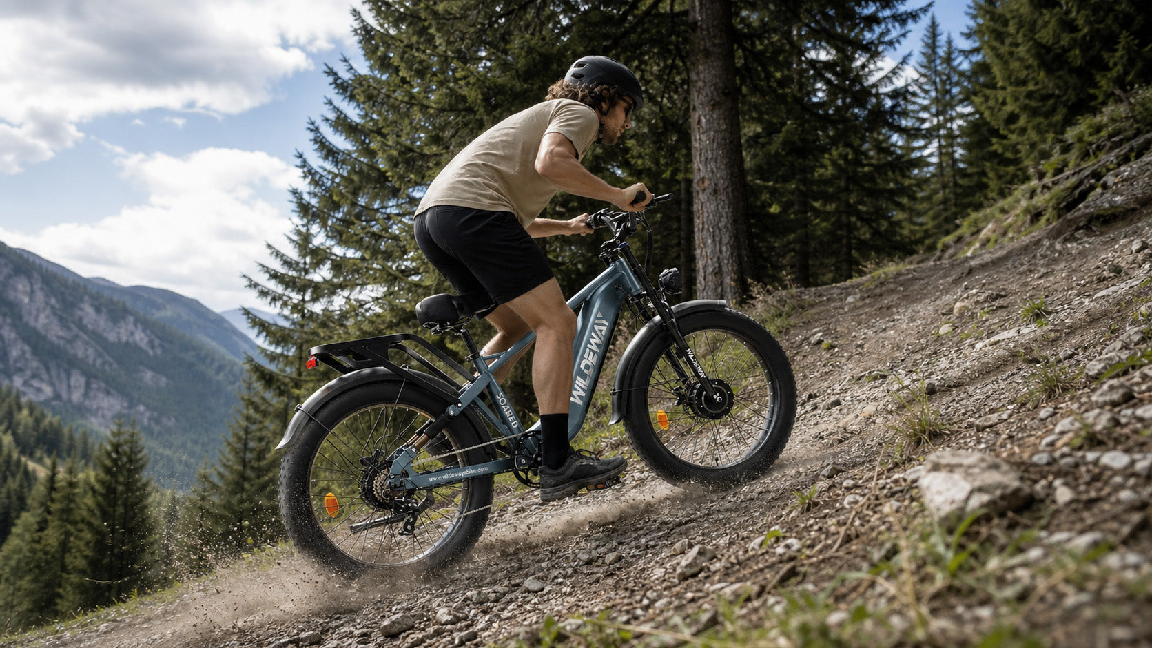 Rider leaning forward, using the WILDEWAY SOARED AWD e-bike and Shimano gears to conquer a steep off-road hill.