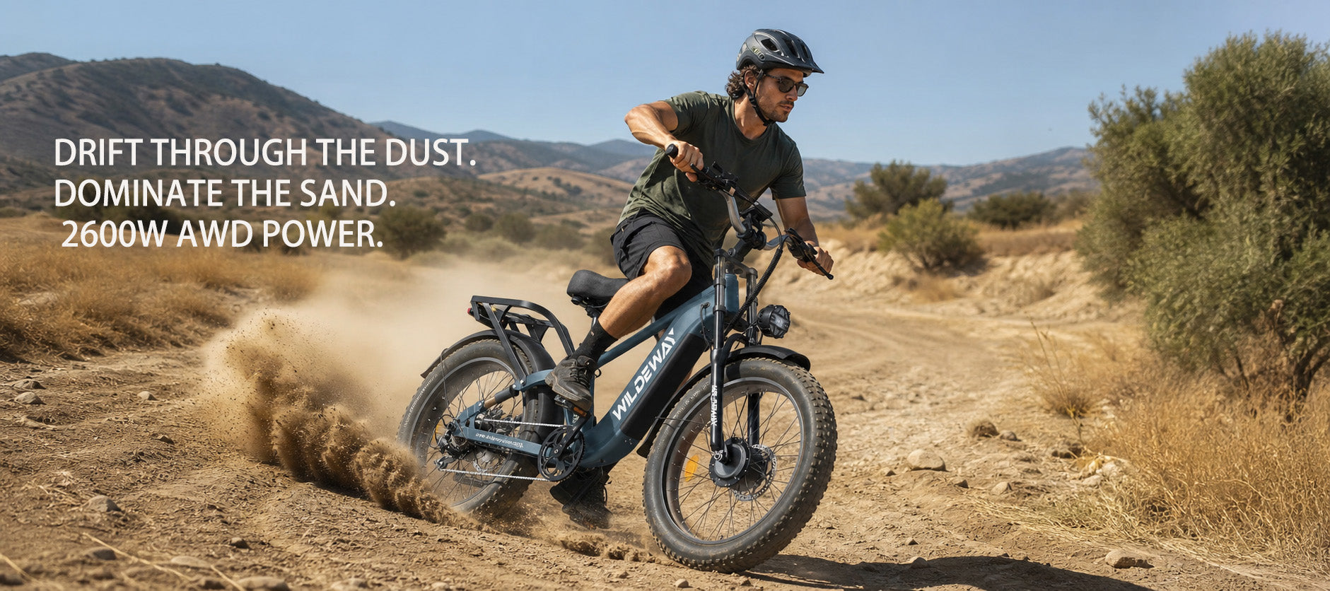 Wildeway Soared Pro Max AWD e-bike drifting through loose sand and dust on a dry summer trail.